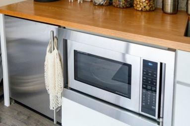 a kitchen counter with a microwave and a potted plant